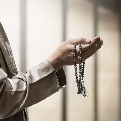 a hand holding religious beads 