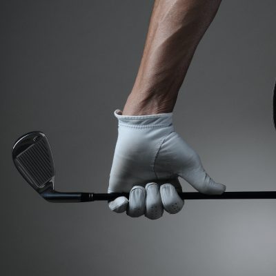 golfer holding a golf club with white golf glove on