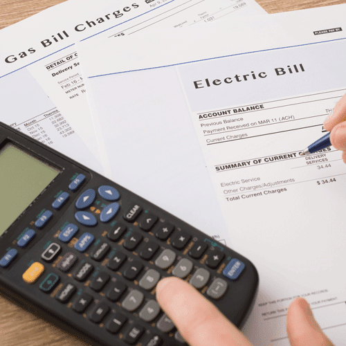 a business owner working out their energy bills with out of contract rates added