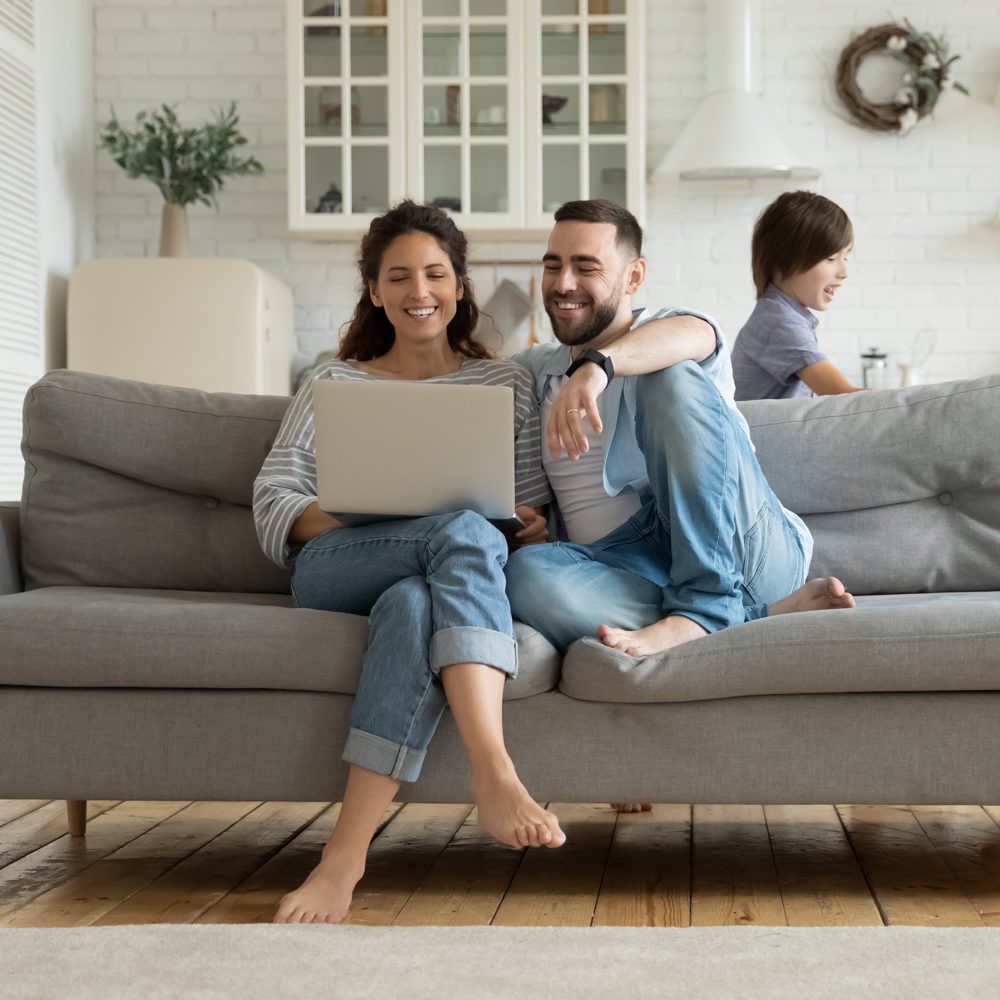 Two people looking at laptop on sofa